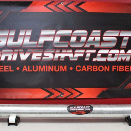 Aluminum driveshaft with a shiny finish, displayed against a red and black promotional backdrop featuring Gulf Coast Driveshaft branding.